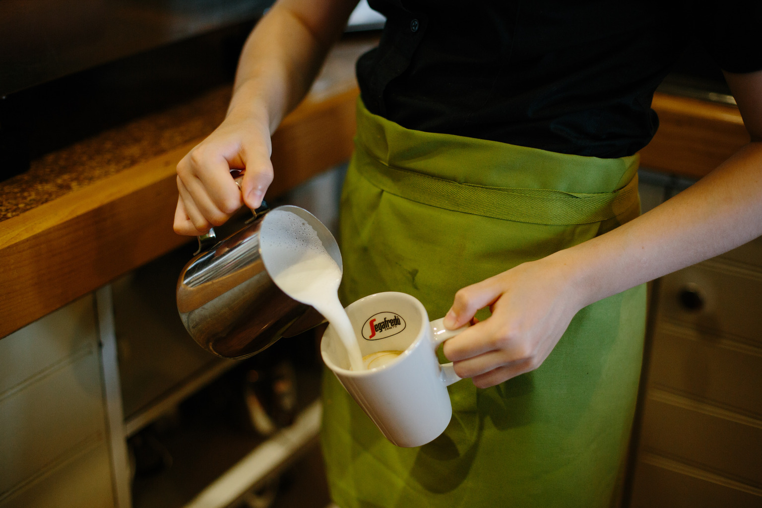 Barista pouring latte